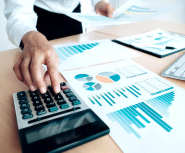 Orçamento empresarial: imagem mostra mulher utilizando calculadora 